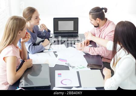 Eine Gruppe von Designern diskutiert ein kreatives Projekt. Das Konzept der Unternehmer, des Erfolgs, des Geldverdienen und der Arbeit. Stockfoto