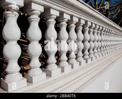 Weiße steinerne Ziersäulen, die einer Reihe von Häusern in South Kensington, London, gegenüberstehen Stockfoto
