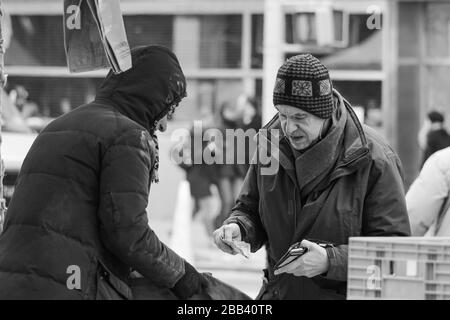 Älterer Mann kauft Lebensmittel an einem kalten Tag auf dem Union Square Greenmarket in Manhattan, New York City, Vereinigte Staaten von Amerika Stockfoto