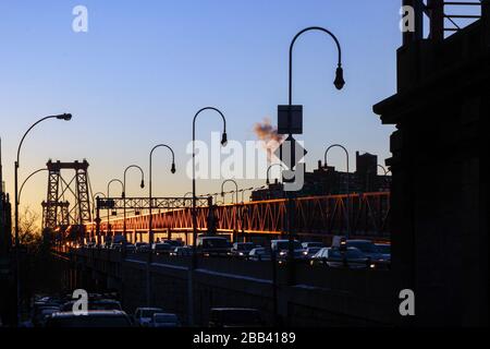 Autos auf dem Lower East Side End der Williamsburg Bridge am frühen Morgen aufgehende Sonne in New York City, Vereinigte Staaten von Amerika Stockfoto