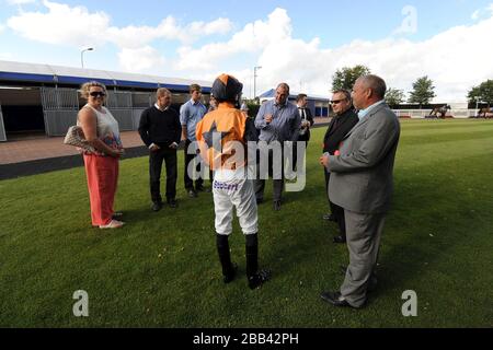 Jockey Martin Leonard spricht mit Trainer von Barathea Dancer, Roger Teal (Center) im Paradering auf der Rennbahn Epsom Downs Stockfoto