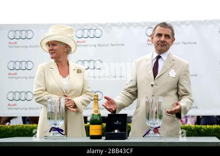 Lady March (l) und Rowan Atkinson bereiten sich darauf vor, Preise für die Gewinner des Magnolia Cup auf der Goodwood Racecourse herauszugeben Stockfoto