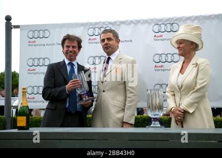 Lady March (r) und Rowan Atkinson (c) vergeben Preise für die Gewinner des Magnolia Cup auf der Goodwood Racecourse Stockfoto