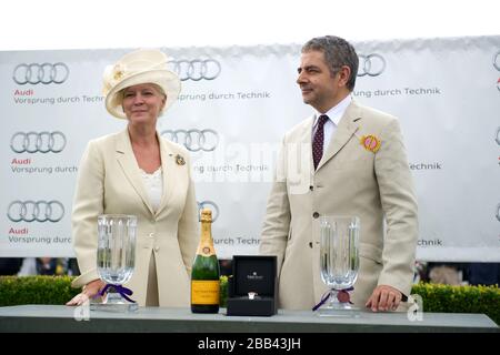 Lady March (l) und Rowan Atkinson bereiten sich darauf vor, Preise für die Gewinner des Magnolia Cup auf der Goodwood Racecourse herauszugeben Stockfoto