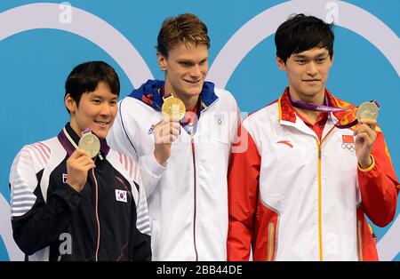 Frankreichs Yannick Agnel (Mitte) mit seiner Goldmedaille auf dem Podium, nachdem er das 200-m-Freistilfinale der Männer gewonnen hatte, mit dem südkoreanischen Taehwan Park (links) und Chinas Yang Sun die Silbermedaille im Aquatics Center im Olympic Park, London, geteilt hatte Stockfoto