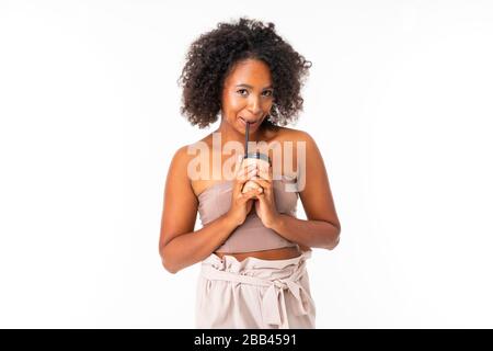 Das Porträt eines schönen afroamerikanischen Weibchens mit kurzen dunklen Haaren in der Schlafkleidung hält eine Tasse Kaffee in der Motte Stockfoto