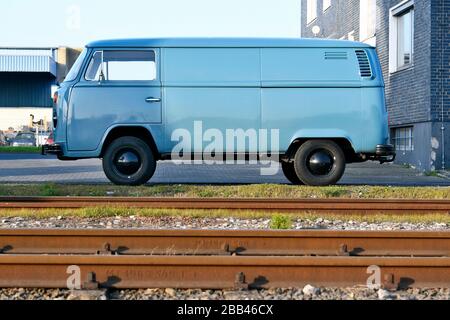 Hellblauer VW-Bus neben Schienen im Düsseldorfer Versandhafen . Stockfoto