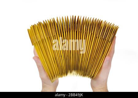 Männliche Hände, die einen Stapel gelber Briefumschläge halten, Draufsicht, isoliert auf weiß. Stockfoto