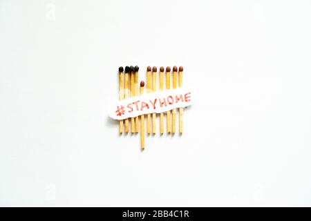 Bleiben Sie zu Hause als #stayathome. Konzept, wie man die Ausbreitung des Coronavirus verhindert. Matchstäbchen brennen, ein Stück verhindert, dass sich das Feuer ausbreitet Stockfoto