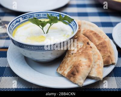 Leckere Tzatziki-Schüssel mit Pita Brot Stockfoto