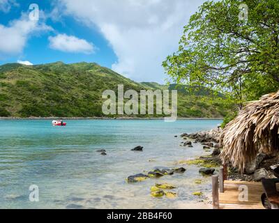 Schnellboot erwartet Sie abseits der Insel in ruhiger Sommerszene auf den karibischen Inseln Stockfoto