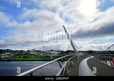 Die berühmte Peace Bridge über Foyle River, in Derry, Nordirland. Es wurde am 25. Juni 2011 eröffnet und verbindet den Ebrington Square mit dem Rest von Stockfoto