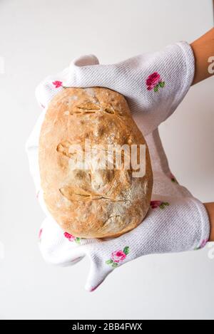 Die Hände der Frau halten frisch gebackenes Brot, von oben Stockfoto