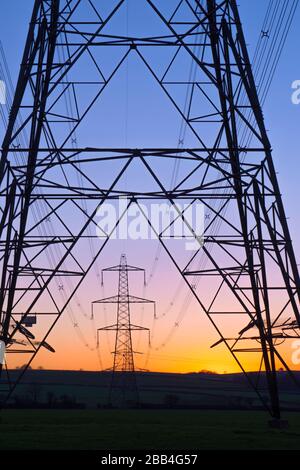 Ein Strommast von National Grid in Wales bei Sonnenuntergang Stockfoto