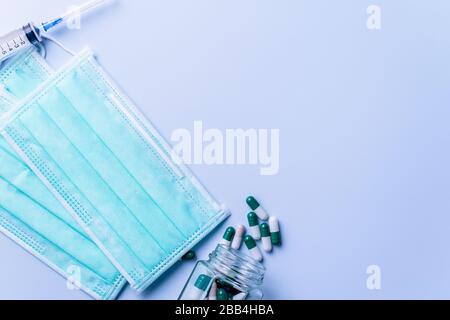 Maske mit Pillen, Stethoskop, Spritze medizinische Versorgungsgegenstände isoliert auf blauem Hintergrund, Draufsicht, Flachlage, Overhead-Shot, Virenschutzkonzept. Stockfoto