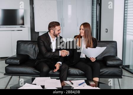 Business Handshake zu treffen oder Verhandlungen im Büro. Partner sind zufrieden, weil Vertrag oder finanziellen Papiere unterzeichnen Stockfoto