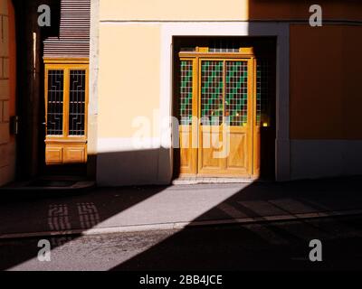 Alte bunte Holztür aus Buntglas, die von starker Sonneneinstrahlung beleuchtet wird. Kontrastreiches Bild. Stockfoto