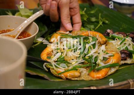 Quy nhon berühmte Straßennahrung namens Springing Shrimps Pfannkuchen oder Banh Xeo tom nhay Stockfoto