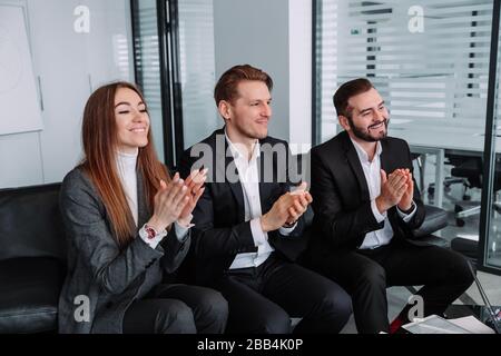 Eine Gruppe von Geschäftsleuten klatscht die Hände, um ihrem Chef zu gratulieren - dem Business Company Team Stockfoto