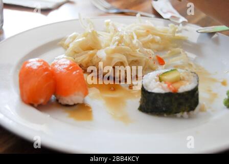 Chinesische Restaurantplatte mit Lachssushis und Coleslaw Stockfoto