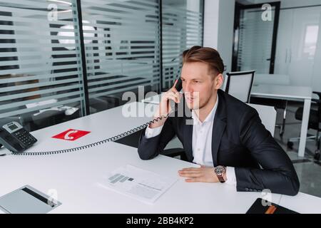 Business man hat Gespräche auf dem Festnetztelefon. Business man im Büro. Stockfoto