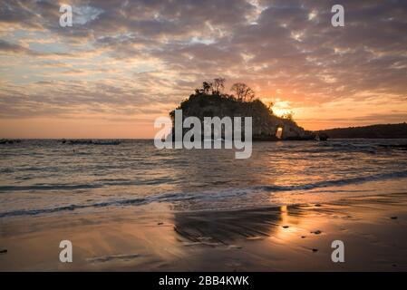 Crystal Bay bei Ebbe mit dem Sonnenuntergang durch die Felsinsel strömende Meerwasser über Felsen und Pfütze in Nusa Penida, Bali, Indonesien Stockfoto