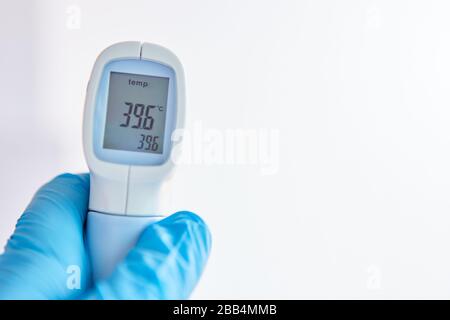 Die Anzeige eines kontaktlosen klinischen Thermometers zeigt Fieber bei einer Covid-19-Epidemie Stockfoto