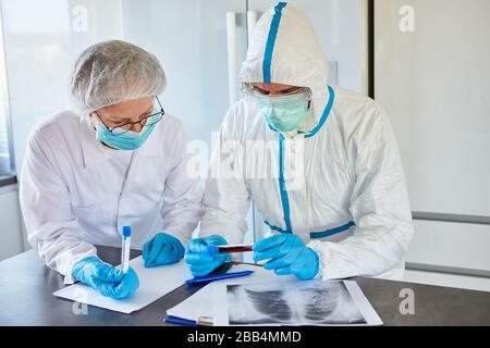 Arzt und Arzt mit Röntgenbild einer Lungenentzündung des Covid-19-Patienten bei einer Coronavirus-Epidemie in der Klinik Stockfoto