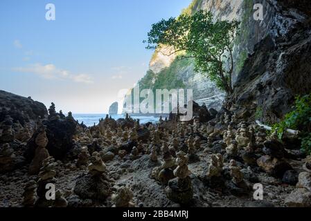 Geheimer Strand von Tembeling, in einem Dschungeltal und einem balinesischen Tempel, mit natürlichem Süßwasserpool und Kieselstrand in Nusa Penida, Bali, Indonesien Stockfoto