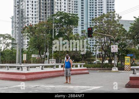 Quezon City. März 2020. Ein Bewohner, der eine Gesichtsmaske trägt, ist am 30. März 2020 an einer leeren Straße in Quezon City auf den Philippinen zu sehen. Credit: Rouelle Umali/Xinhua/Alamy Live News Stockfoto