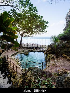 Geheimer Strand von Tembeling, in einem Dschungeltal und einem balinesischen Tempel, mit natürlichem Süßwasserpool und Kieselstrand in Nusa Penida, Bali, Indonesien Stockfoto