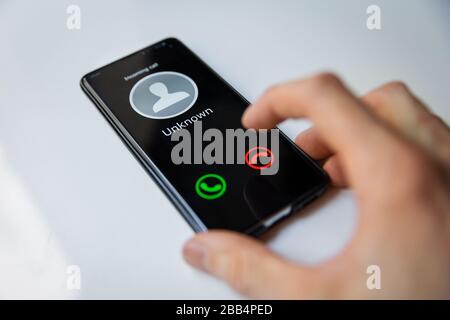Smartphone mit ankommendem Anruf von unbekannter Person Stockfoto