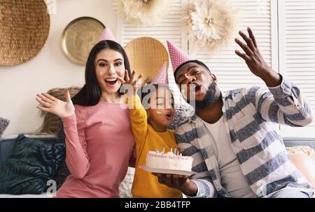 Internationale Familie in den Kappen verschmiert in Kuchen Stockfoto