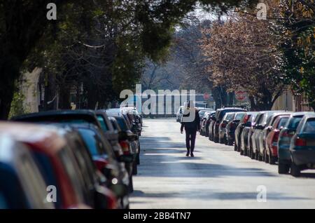ALEXANDROUPOLI, GRIECHENLAND - 21. März 2020 - EINE Einzelperson spaziert während der COVID-19-Sperre mitten in der Straße in Alexandroupoli Griechenland. Stockfoto