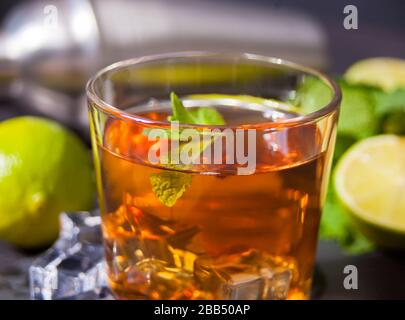 Frischer Cocktail Cuba Libre oder Whiskey Cola Cocktail mit braunem Rum, Cola, Minze und Limette auf schwarzem Hintergrund. Long Island Iced Tea Cocktail. Stockfoto