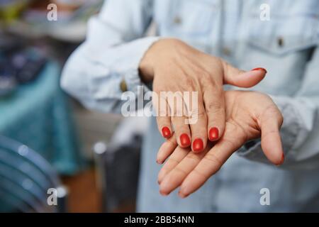 Frau, die zur Desinfektion eine feuchtigkeitsspendende Lotion verwendet Stockfoto