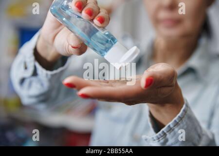 Frau, die eine feuchtigkeitsspendende Lotion zur Desinektion verwendet Stockfoto