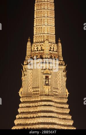 Detail des Arun-Tempels, einer der berühmtesten in Bangkok, Taliandia, steht oben, nachts beleuchtet, am Ufer des Chao-Phraya-Flusses. Stockfoto