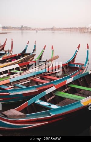 Bunte kleine Holzboote auf dem Taung Tha man Lake in der Nähe der berühmten U-Bein-Brücke. Stockfoto