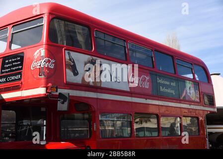 London, Großbritannien - 22. Februar 2015: EIN nostalgisches grafisches Coca-Cola-Werbeplakat auf einem traditionellen roten London Double Decker Bus. Stockfoto