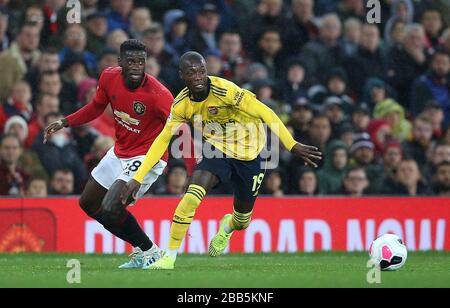 Gegen den Ball kämpfen Manchester United Axel Tuanzabe (links) und Arsenals Nicolas Pepe Stockfoto