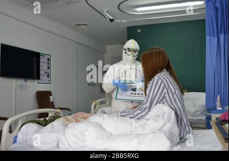 Peking, China. März 2020. (200330) -- PEKING, 30. März 2020 (Xinhua) -- EIN medizinischer Mitarbeiter kommuniziert mit einem Patienten im Xiaotangshan Krankenhaus in Peking, Hauptstadt Chinas, 30. März 2020. Das Xiaotangshan Hospital, das früher zur Quarantäne von SARS-Patienten in Peking verwendet wurde, sah seinen ersten Patienten der neuartigen Coronavirus-Krankheit (COVID-19), die nach der Genesung am Montag entlassen wurde. Kredit: Xinhua/Alamy Live News Stockfoto