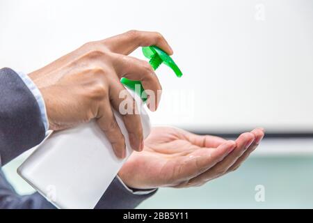 Der Mann, der mit Handdesinfektions-Alkoholgel reibt, um die Hygiene der Hände zu Hause oder im öffentlichen Raum zu gewährleisten, die Klinik für vorbeugende Corona-Virusverbreitung preven Stockfoto