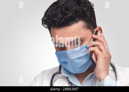 Porträt des asiatischen Arztes auf weißem Hintergrund, telefonische Unterhaltung. Ich schauend traurig Stockfoto