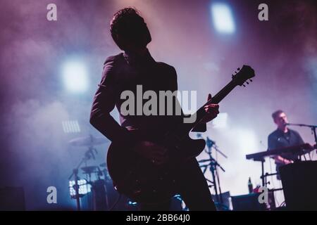 Silhouette eines Mannes, der auf der Bühne Gitarre spielt. Dunkler Hintergrund, Rauch, Strahler Stockfoto