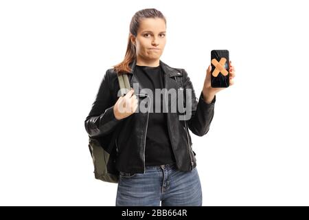 Enttäuschte Studentin mit einem kaputten Handy und Pflaster auf dem Bildschirm isoliert auf weißem Hintergrund Stockfoto