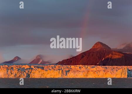 Regenbogen über den Kongsbreen-Gletscher bei Sonnenuntergang, abends in den Kongsfjorden, Svalbard/Spitzbergen, Norwegen Stockfoto