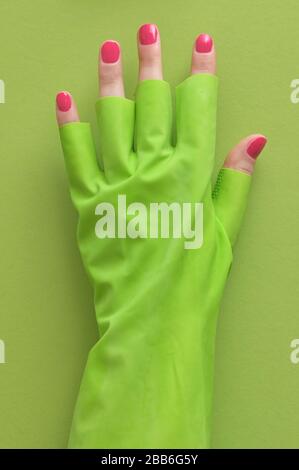 Abstrakte Hand in Latex-Handschuh aus Gummi und Roter Nagelpolitur Stockfoto