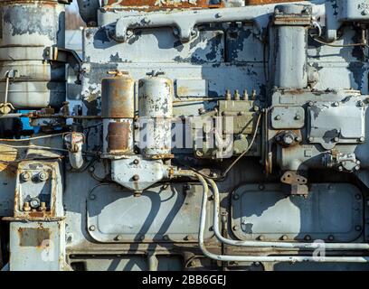 Hintergrund des alten Motors (Motor, Werkzeugmaschine, Mechanismus). Altes Metallfragment einer Dampf- oder Gasmaschine eines Traktors oder Zuges. Stockfoto