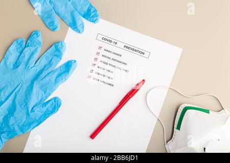 Coronavirus-Beratungs- oder Präventionskonzept. Draufsicht einer COVID-19-Prüfliste und Sicherheitsausrüstung Stockfoto